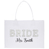 A white tote bag with the word "BRIDE" and the name "Mrs. Smith" printed on it.