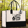 A white tote bag with black trim and a printed design on it, placed on a wooden surface with a forest background.
