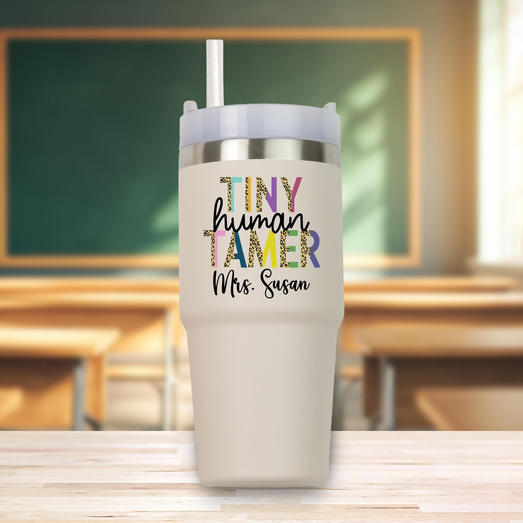 a white cup with a straw in it sitting on a table