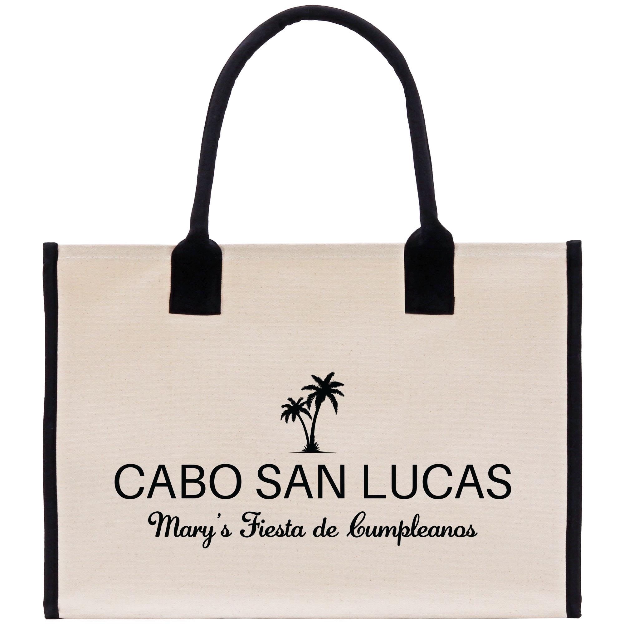 a white bag with black handles and a palm tree on it