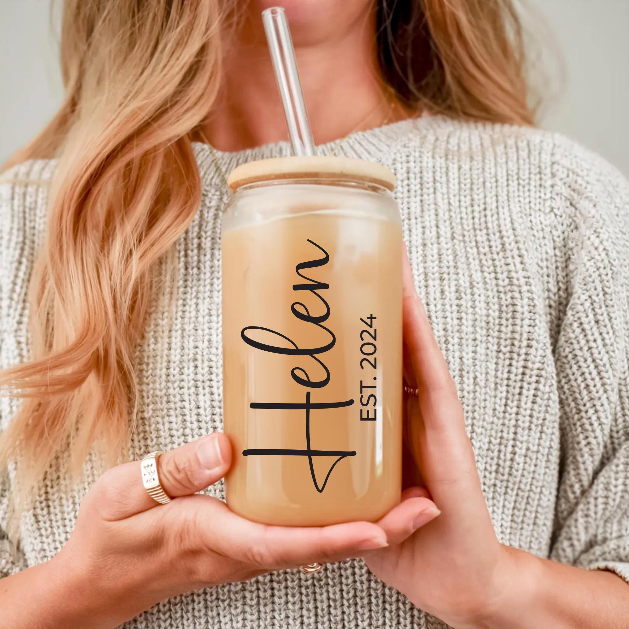 a woman holding a drink with a straw in her hand