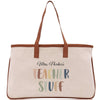 A beige canvas tote bag with a brown leather strap and the text "Mrs. Parker's Teacher Stuff" printed on it.