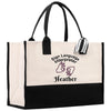 A beige tote bag with a black handle and straps, featuring a printed design on the front that says "Sign Language Interpreter Heather".