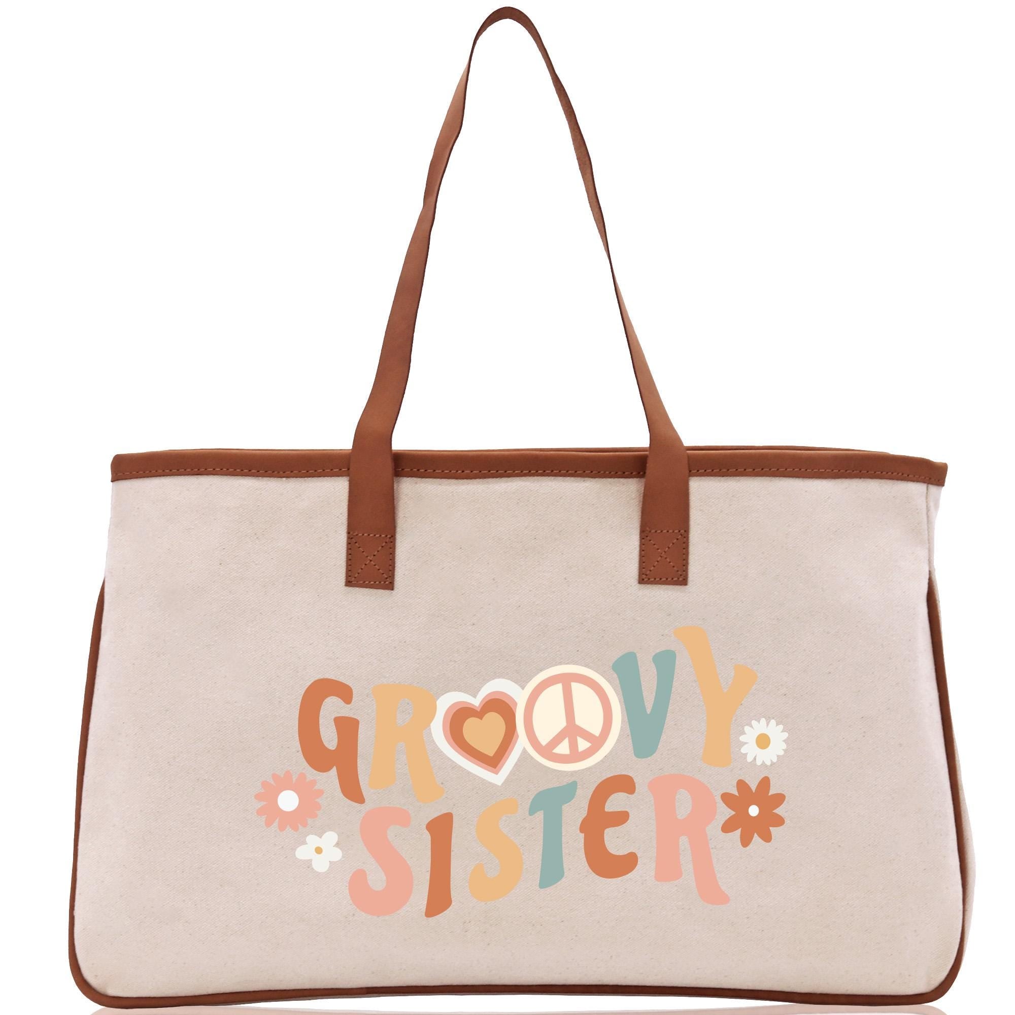 A beige tote bag with the text &quot;GROOVY SISTER&quot; printed on it.