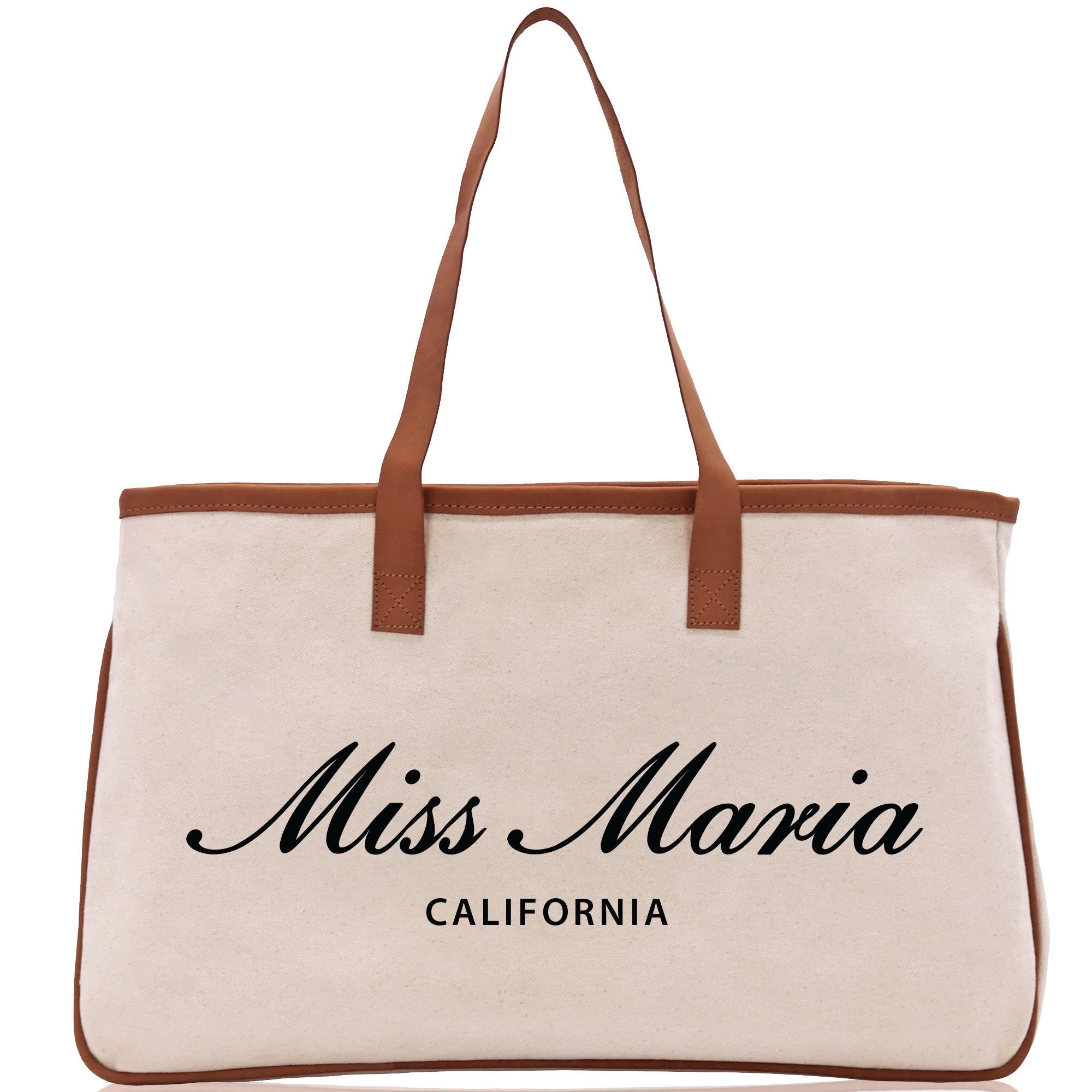 a white canvas bag with a brown leather handle