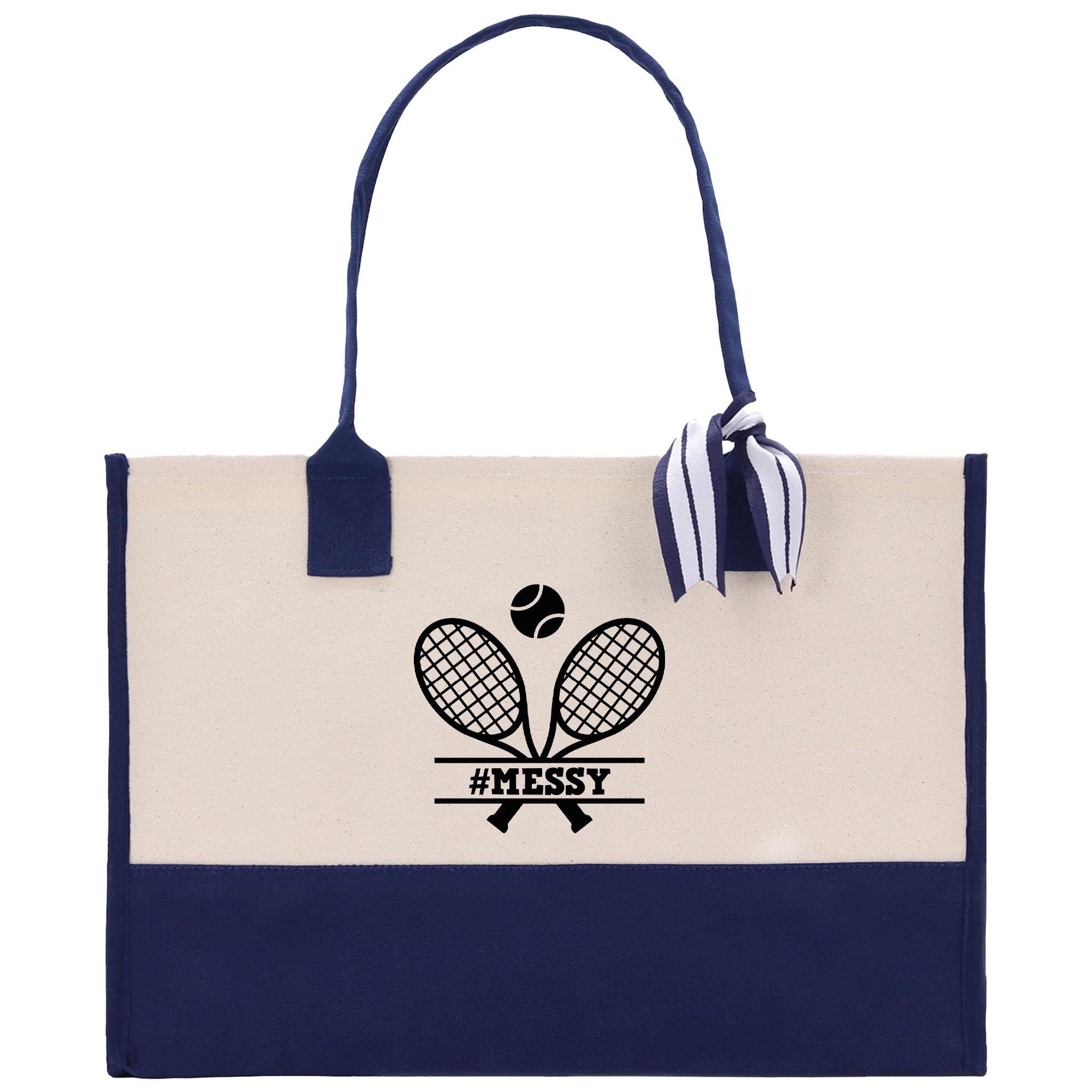 A navy blue and cream tote bag with a tennis racket and ball graphic printed on it, along with the text &quot;#MESSY&quot; printed below.