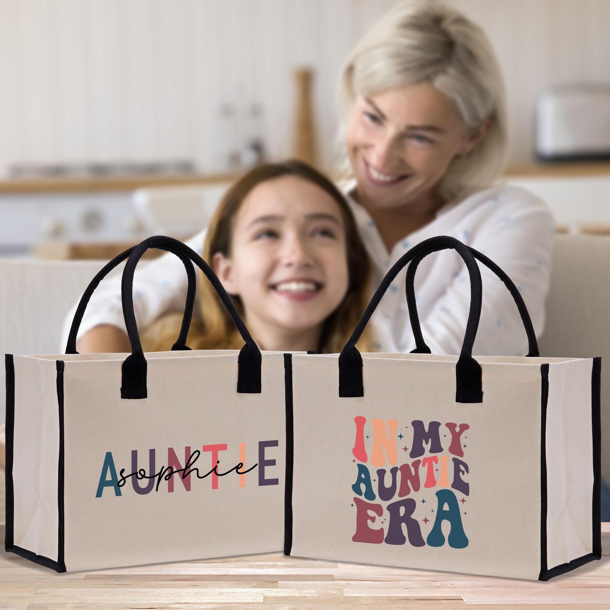a woman and a girl sitting on a couch with two bags in front of them