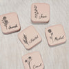 four coasters with flowers on them sitting on a table