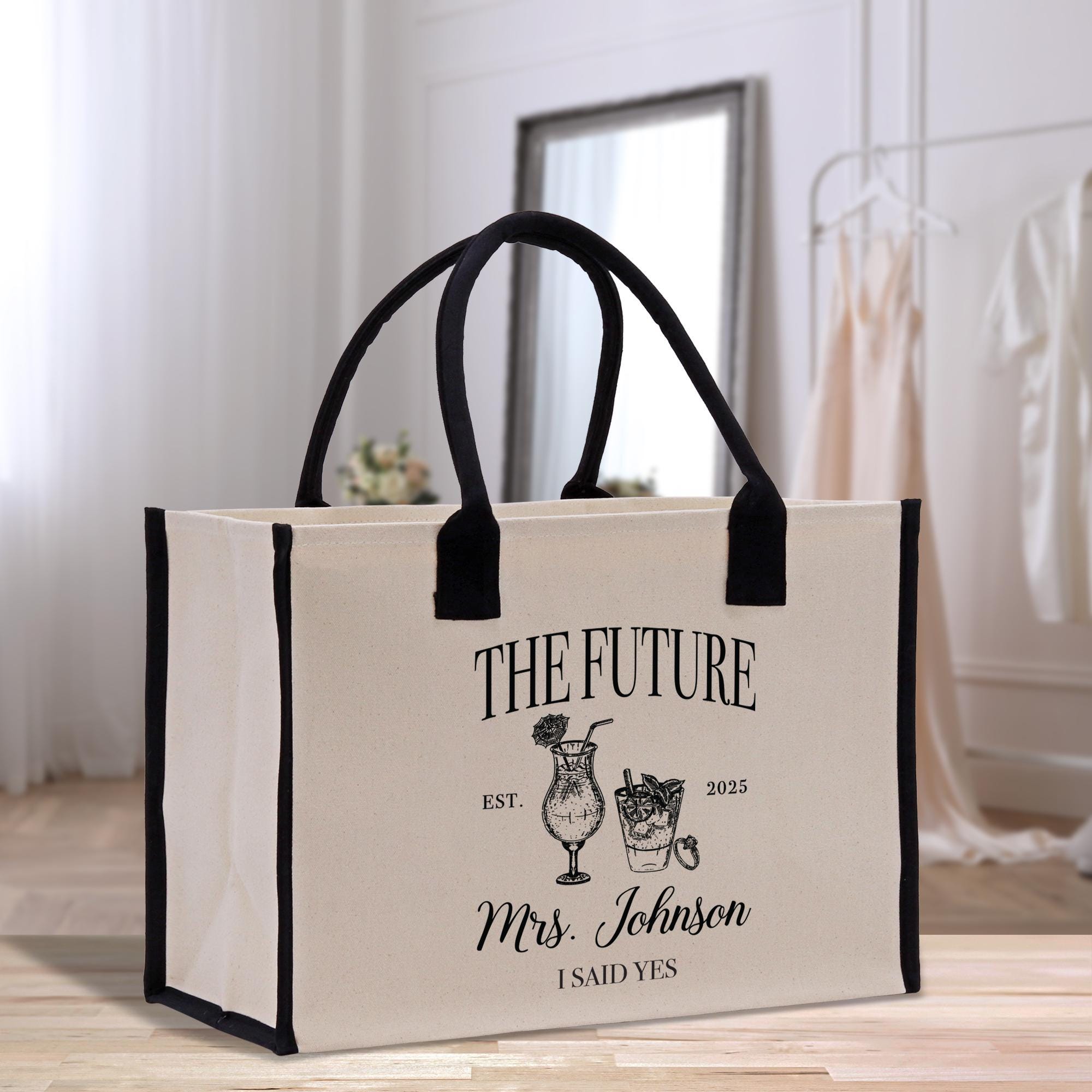 a white bag with a black handle on a wooden floor