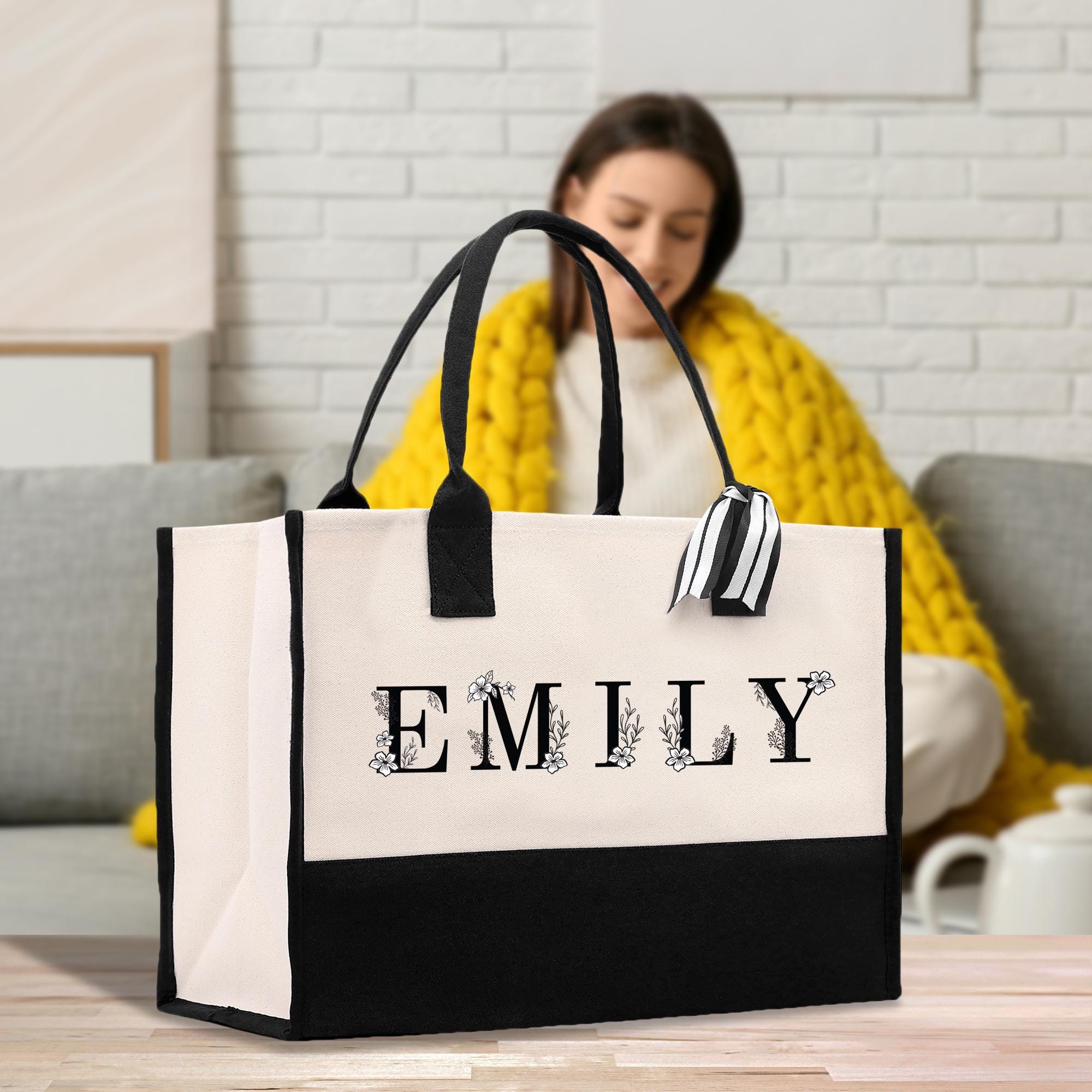 a woman sitting on a couch holding a black and white bag