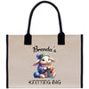 a canvas bag with a picture of a bunny knitting a ball of yarn