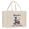 a white shopping bag with a picture of a bunny holding a yarn ball