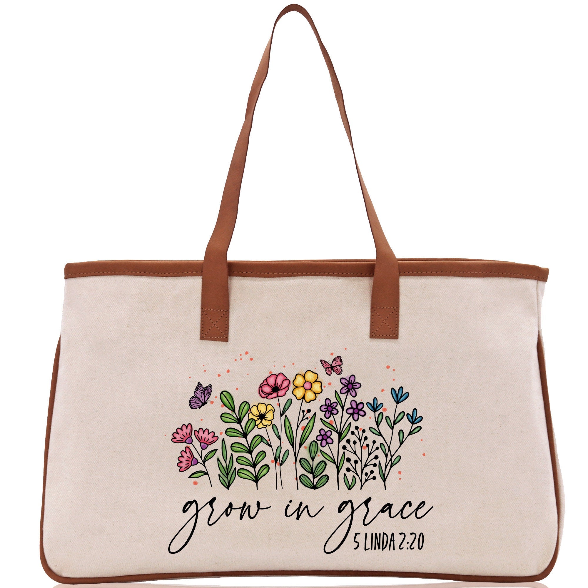 a white canvas bag with flowers and a brown leather handle