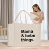 a woman holding a bag that says mama and bebe things