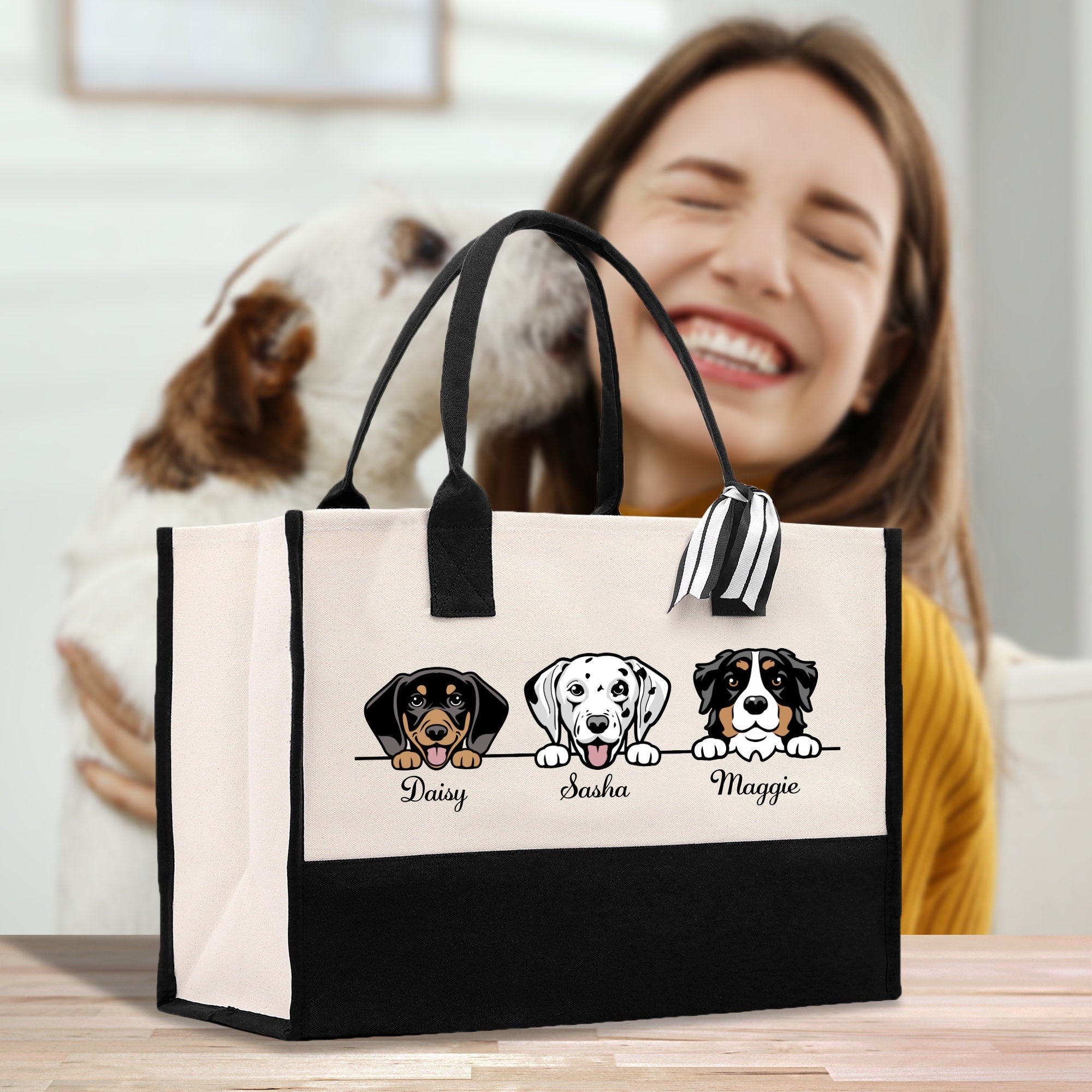 a woman sitting at a table holding a bag with three dogs on it