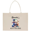 a white shopping bag with a picture of a bunny knitting a ball of yarn