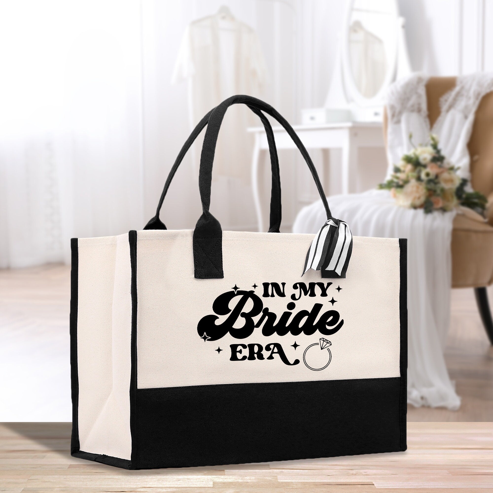 a black and white tote bag sitting on top of a wooden floor