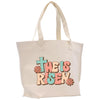 a white tote bag with a cross on it