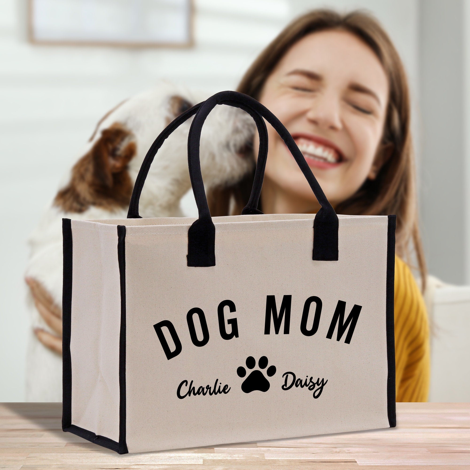 a woman sitting at a table with a dog in a bag