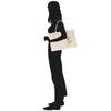 a silhouette of a woman carrying a shopping bag