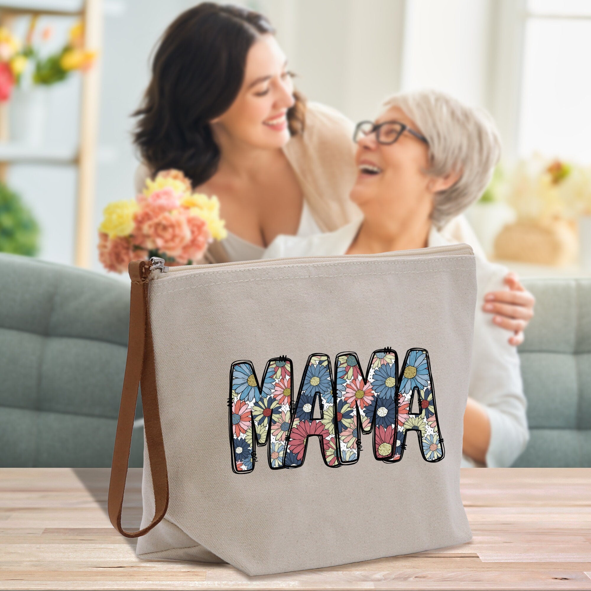 a woman and a woman sitting on a couch holding a bag with the word mama