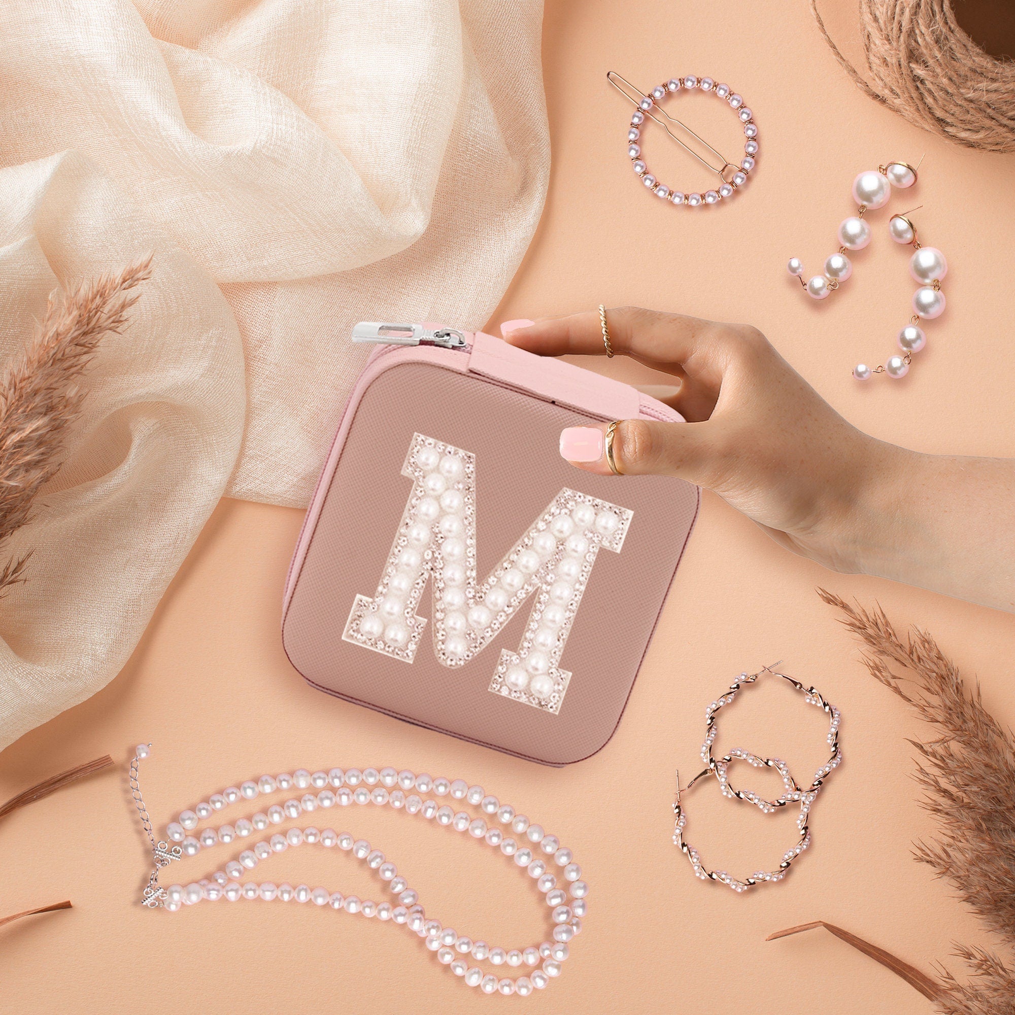 a woman&#39;s hand is holding a pink case with the letter m on it