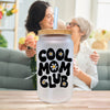 a woman holding a glass with the words cool mom club on it