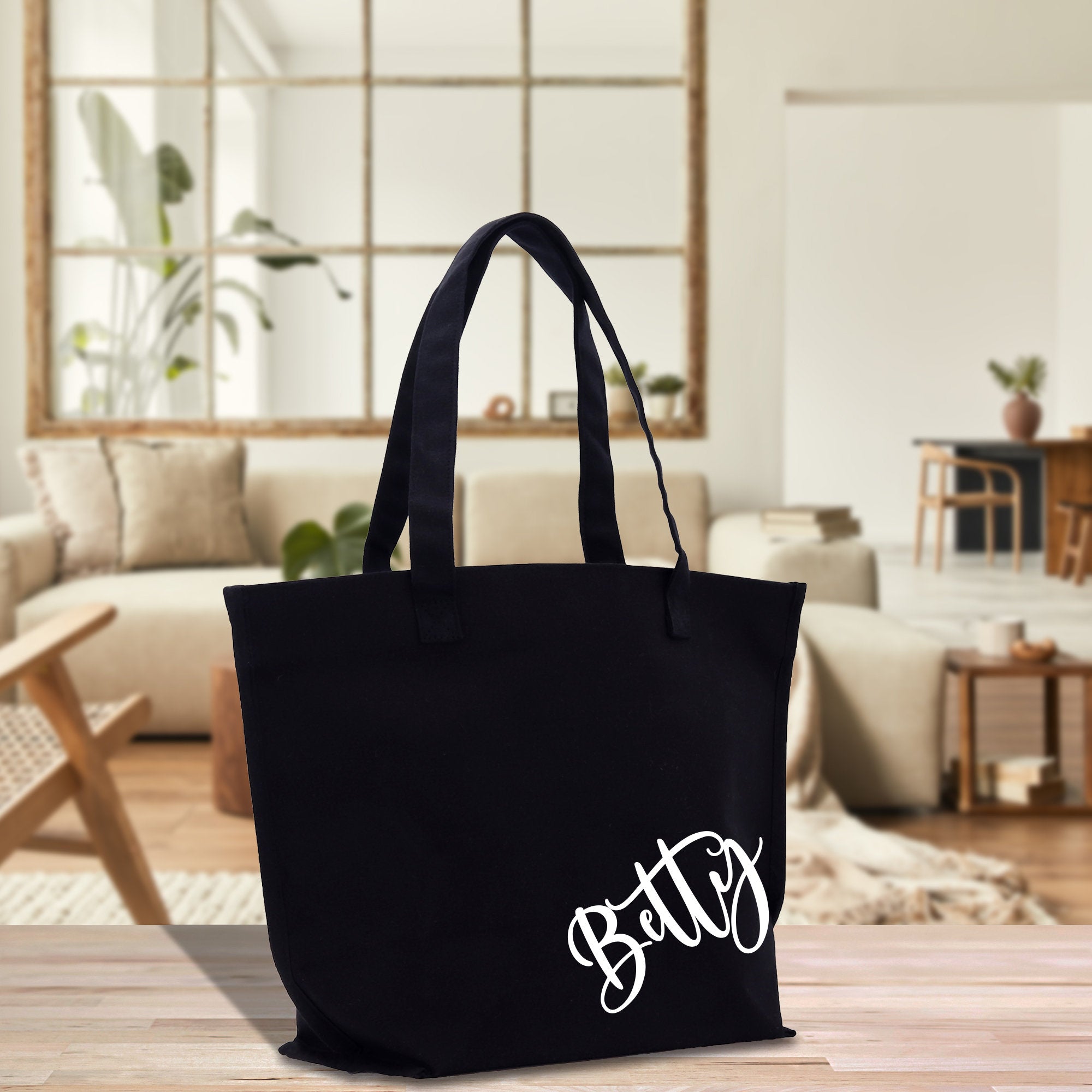 a black tote bag sitting on top of a wooden table