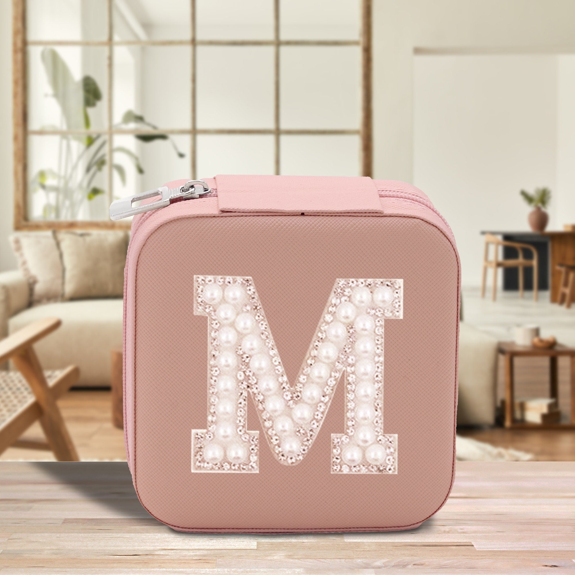 a pink suitcase with the letter m on it