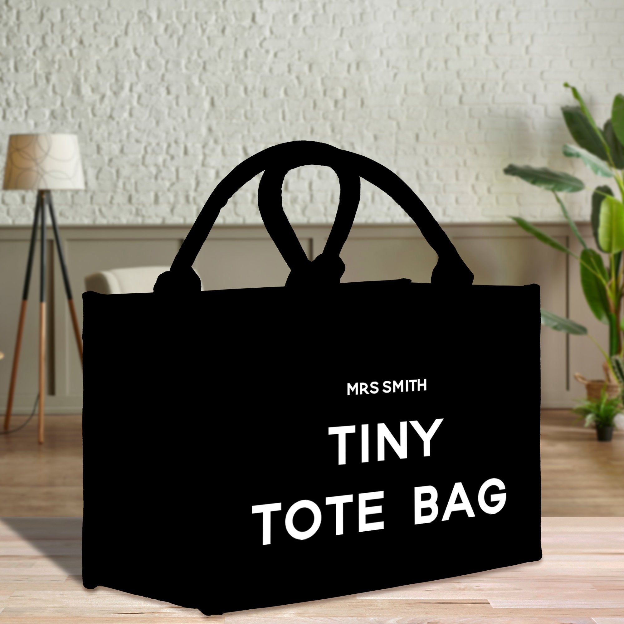 a black bag with the words tiny tote bag printed on it