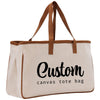 a canvas tote bag with a brown leather strap