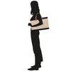 a silhouette of a woman carrying a bag