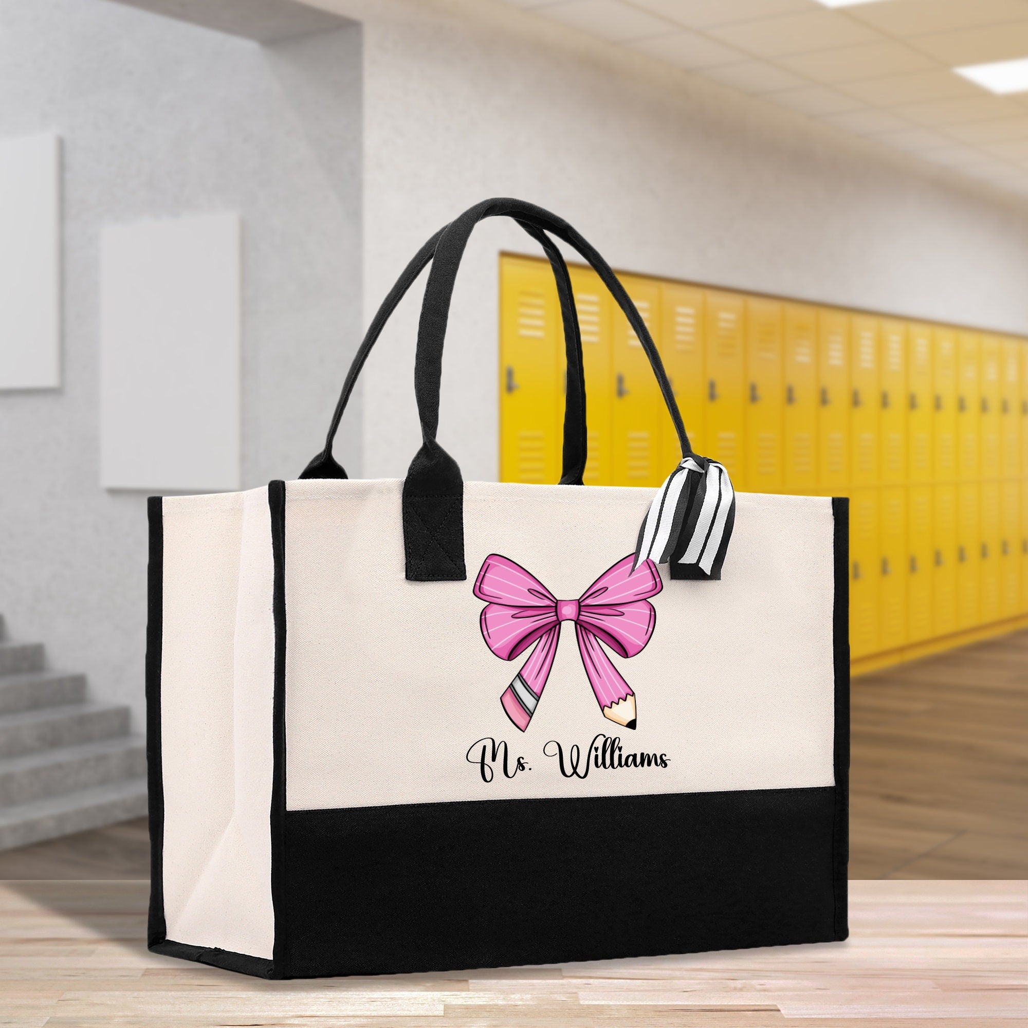 a black and white bag with a pink bow on it