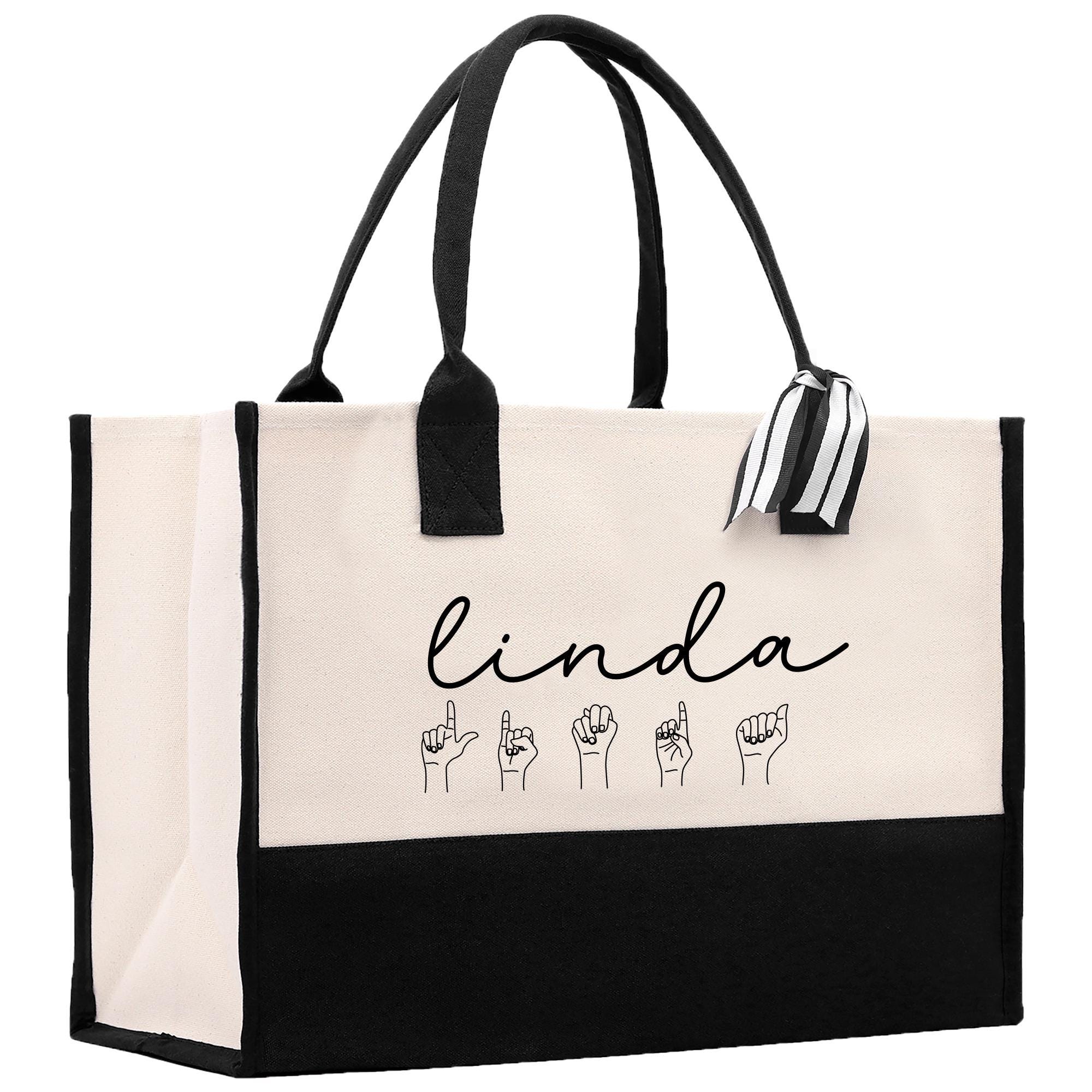 a black and white shopping bag with a black handle