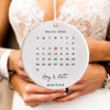 a bride and groom holding a calendar ornament