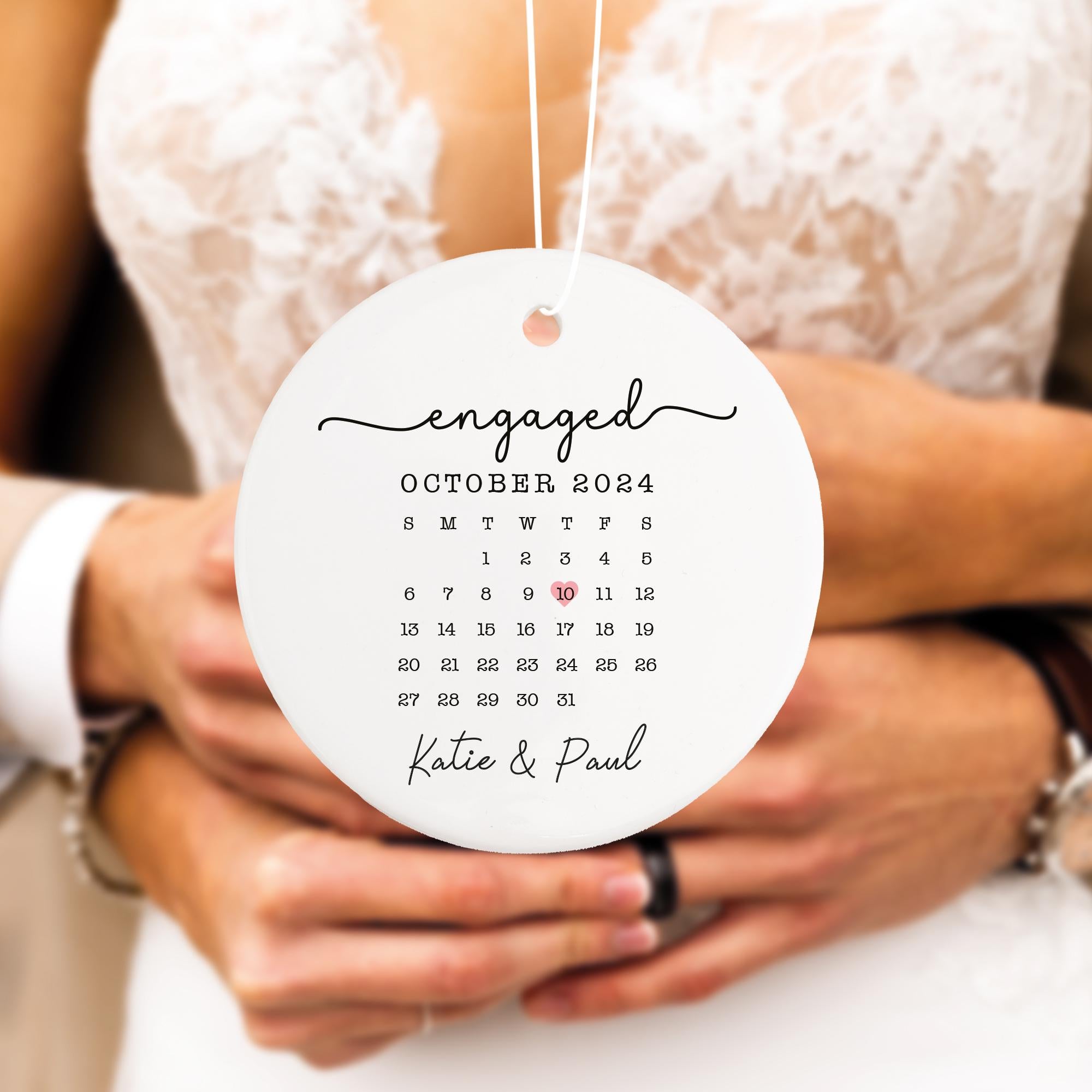 a newly married couple holding a calendar ornament