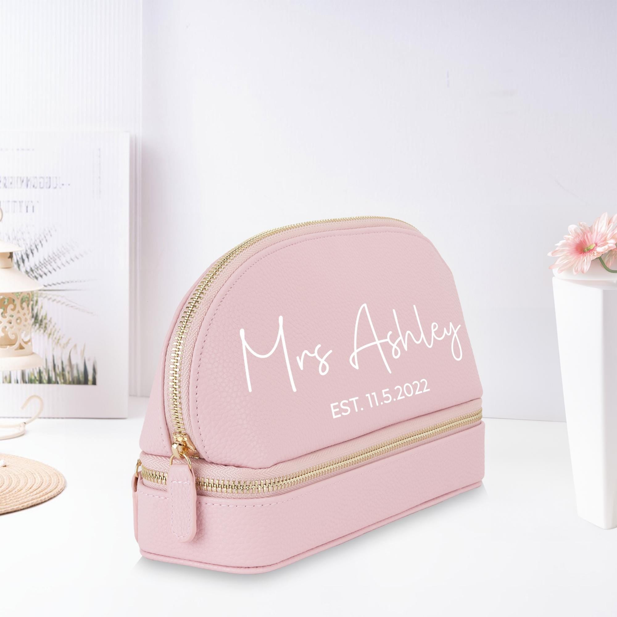 a pink makeup bag sitting on top of a table