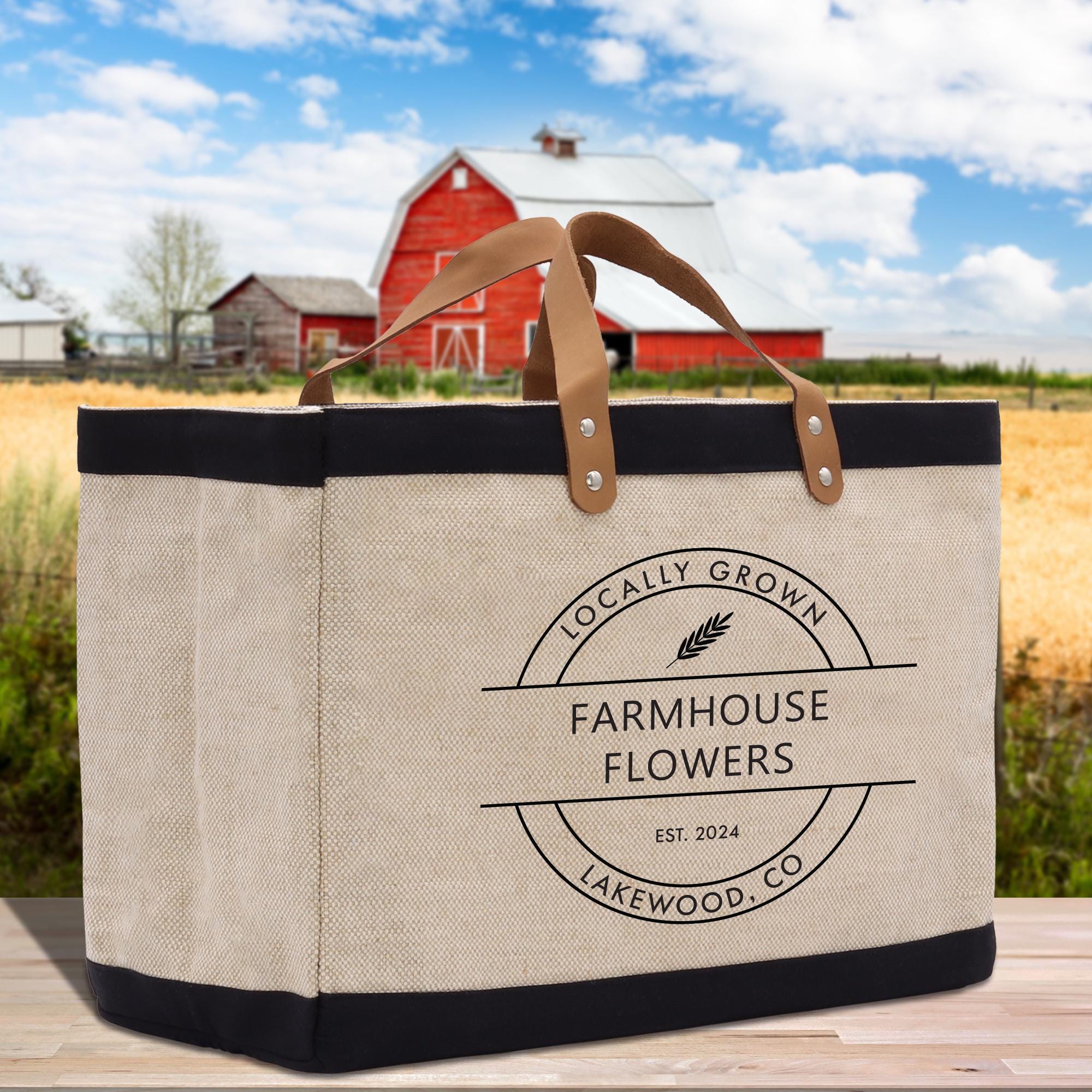 a canvas bag sitting on a wooden table in front of a red barn