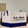 a white and blue shopping bag sitting on top of a wooden table