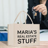 a woman holding a key to a bag that says maria's real estate stuff