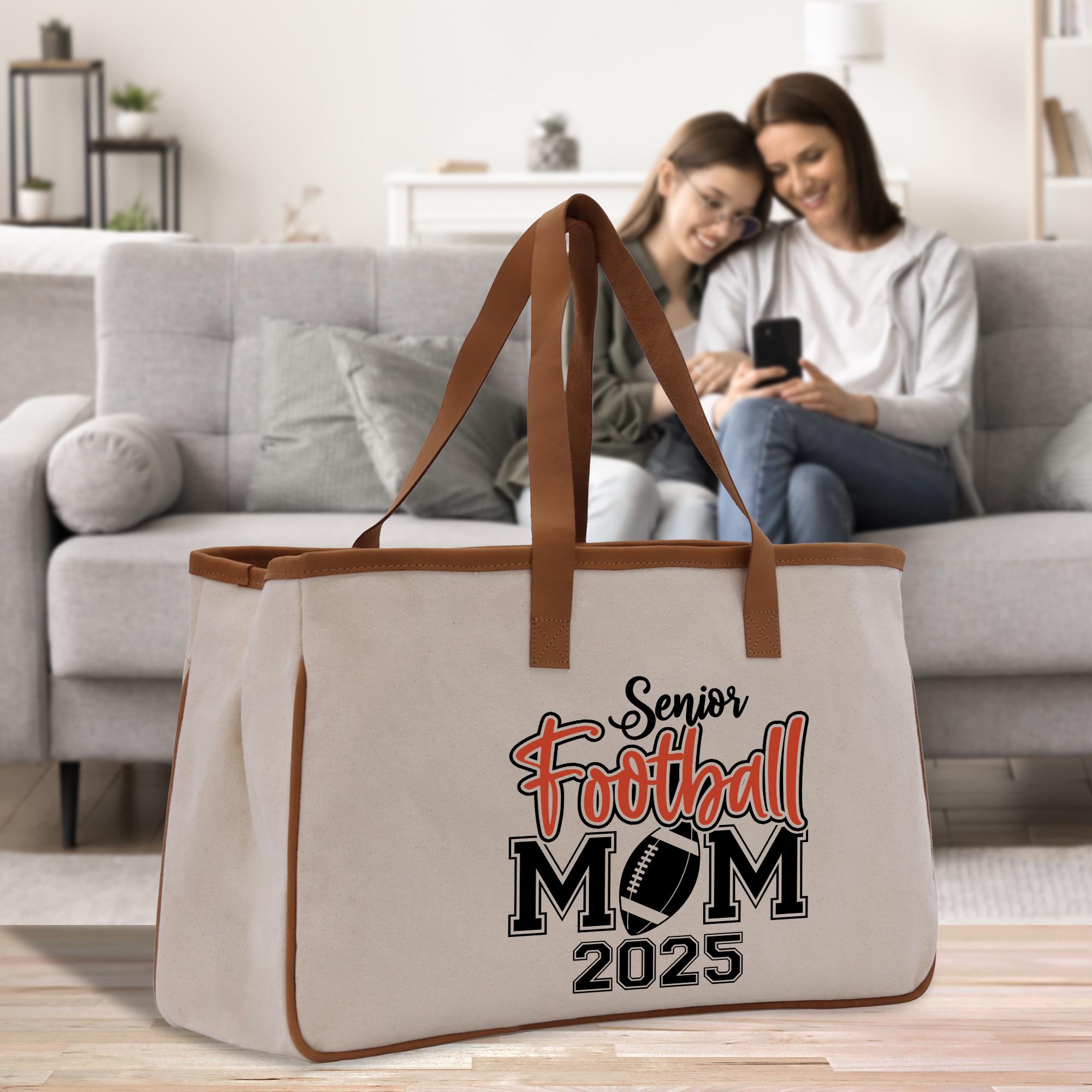 two women sitting on a couch looking at a cell phone