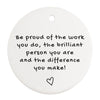 a white ornament with a quote on it