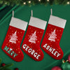 three christmas stockings hanging from a christmas tree