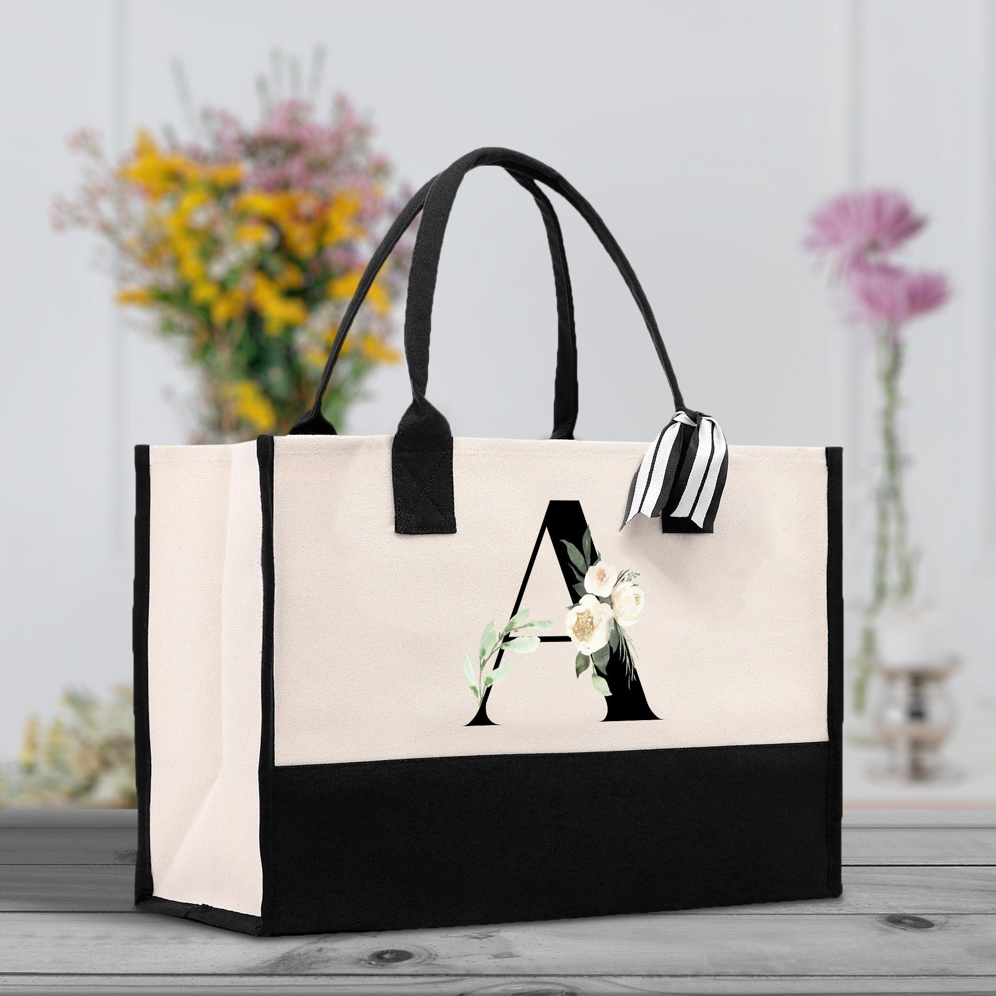 a black and white shopping bag with a monogrammed letter