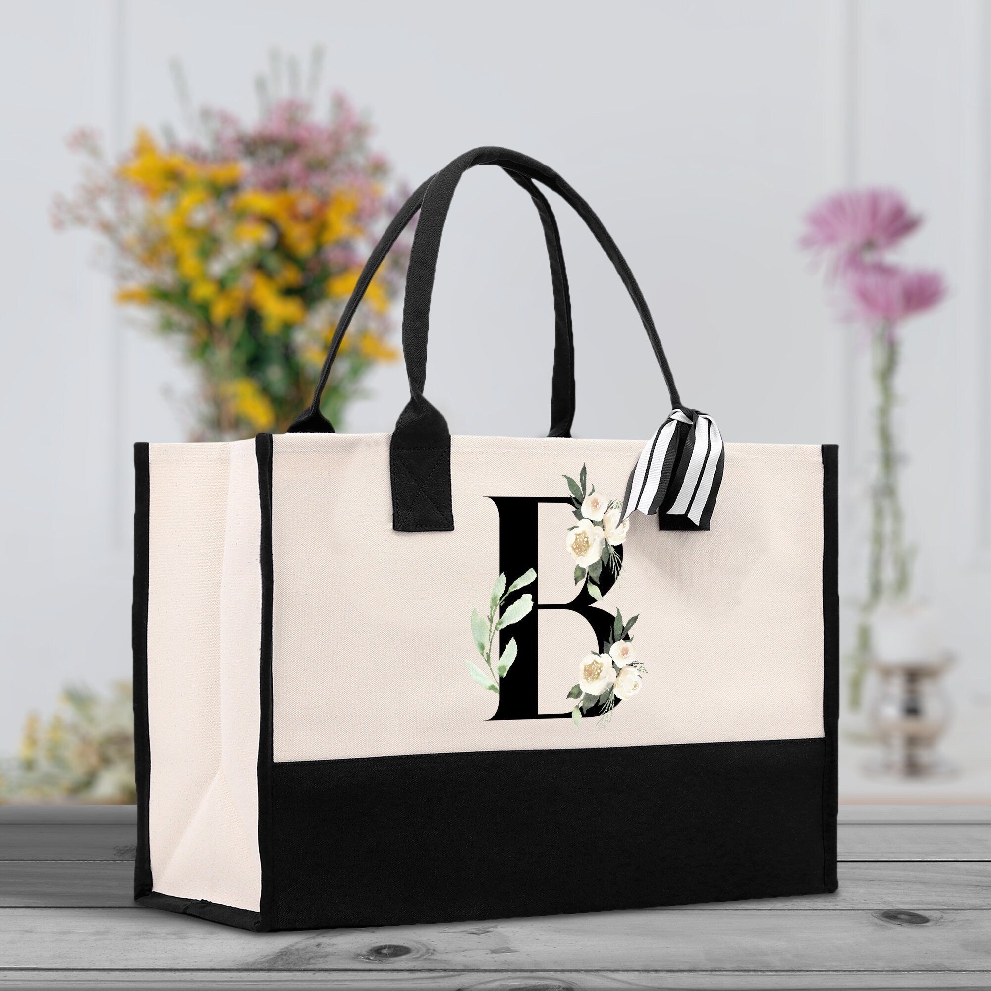 a black and white bag with a monogrammed flower on it