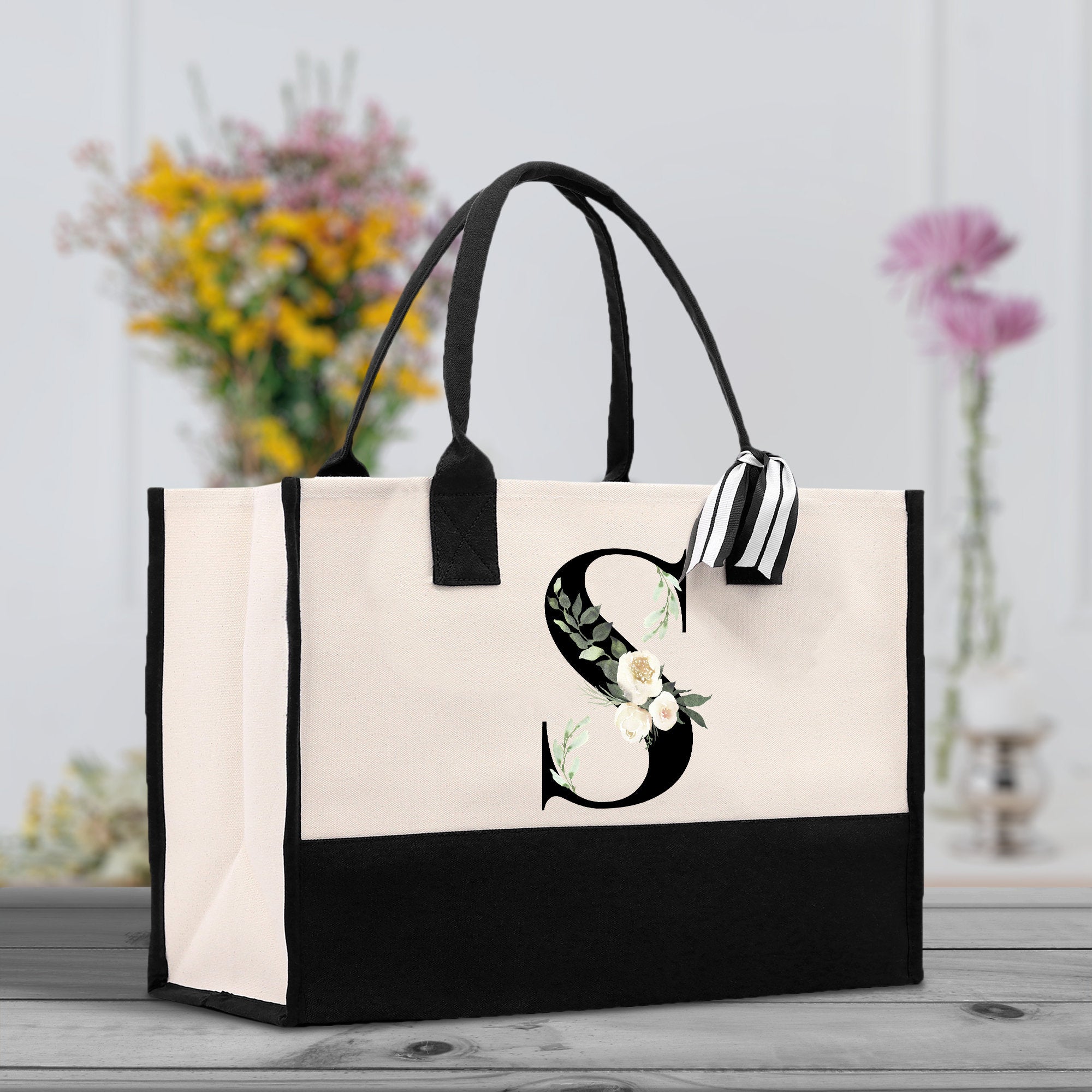 a black and white bag with a flower on it