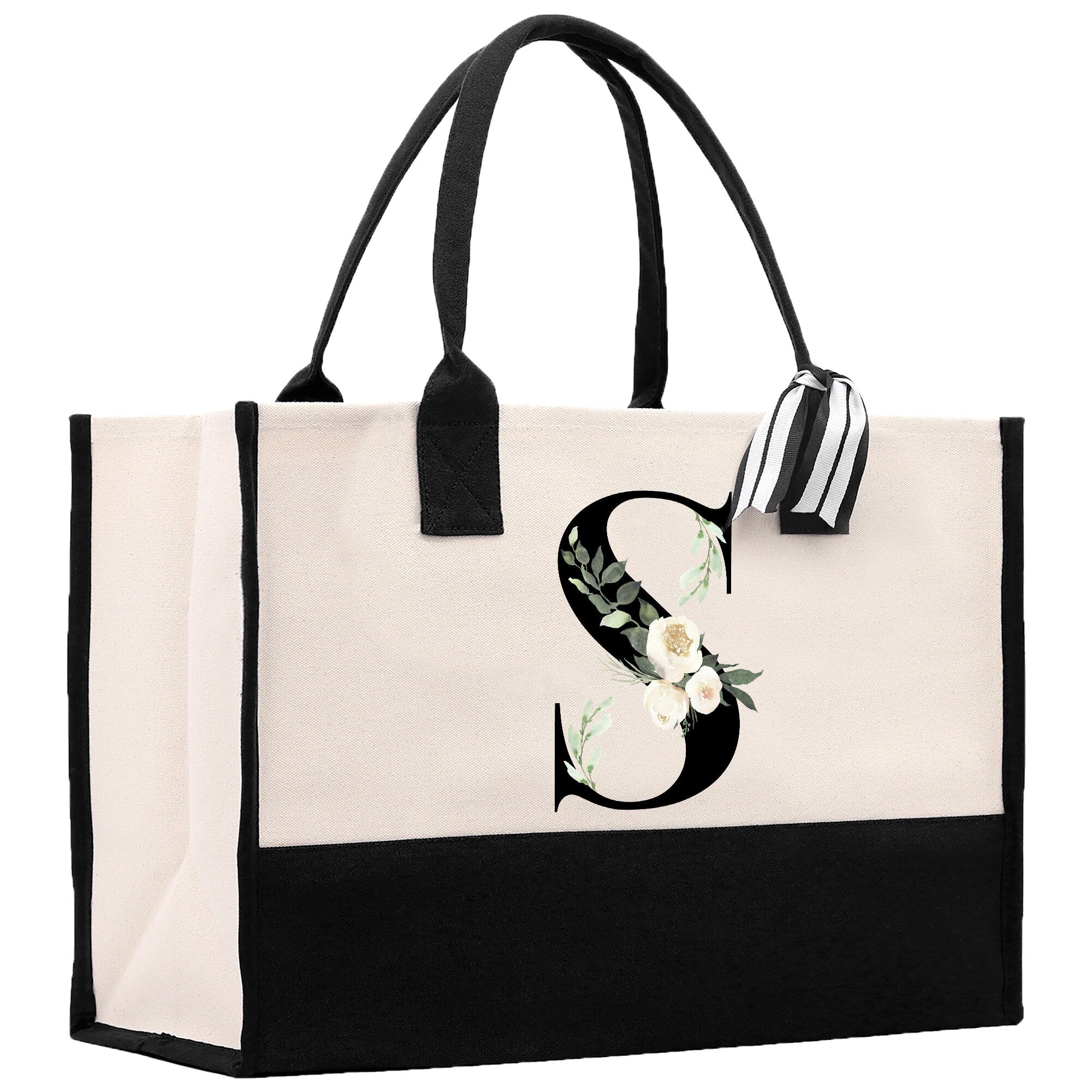 a black and white tote bag with a flower monogrammed on the front