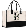 a black and white tote bag with a monogrammed flower