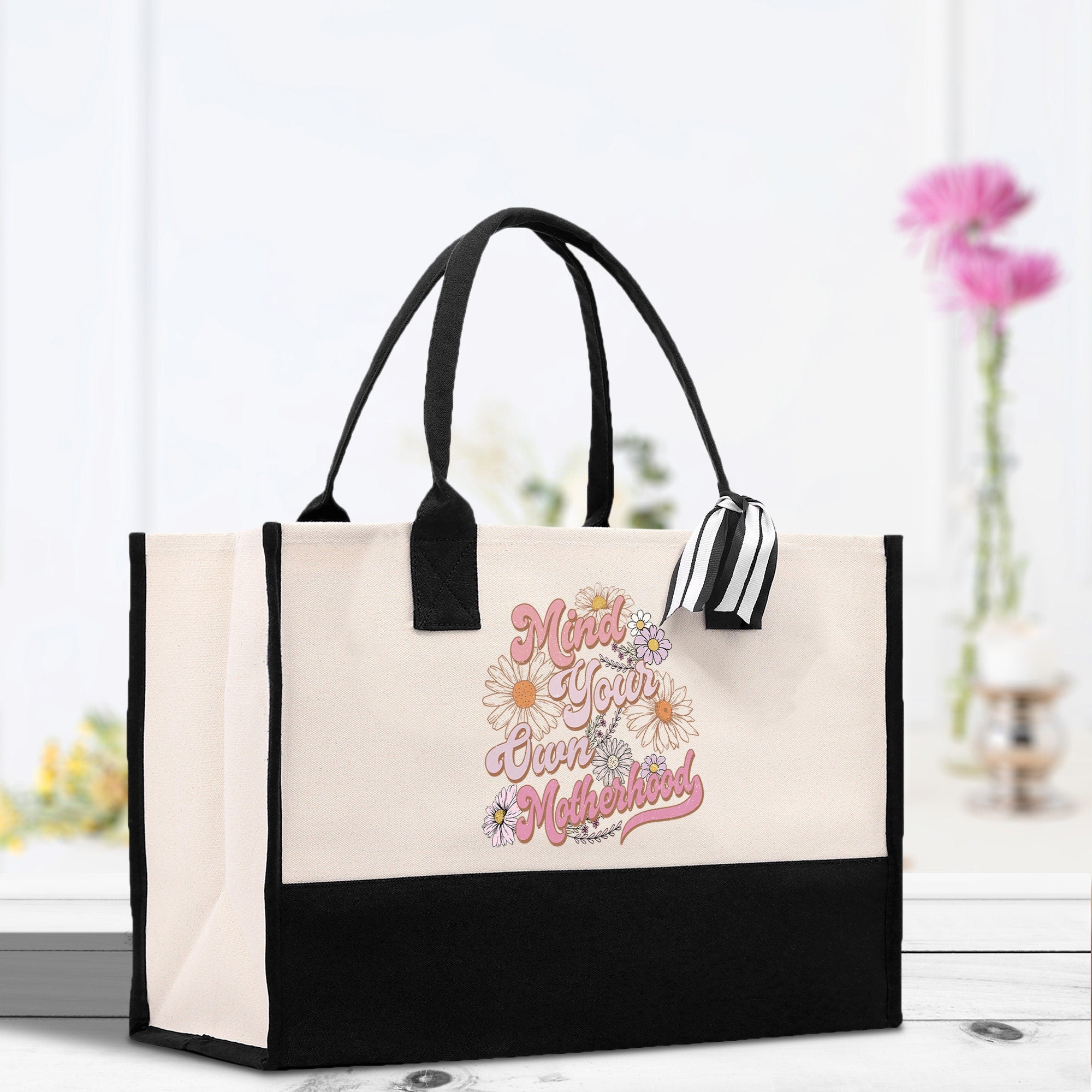 a black and white bag with a pink flower on it