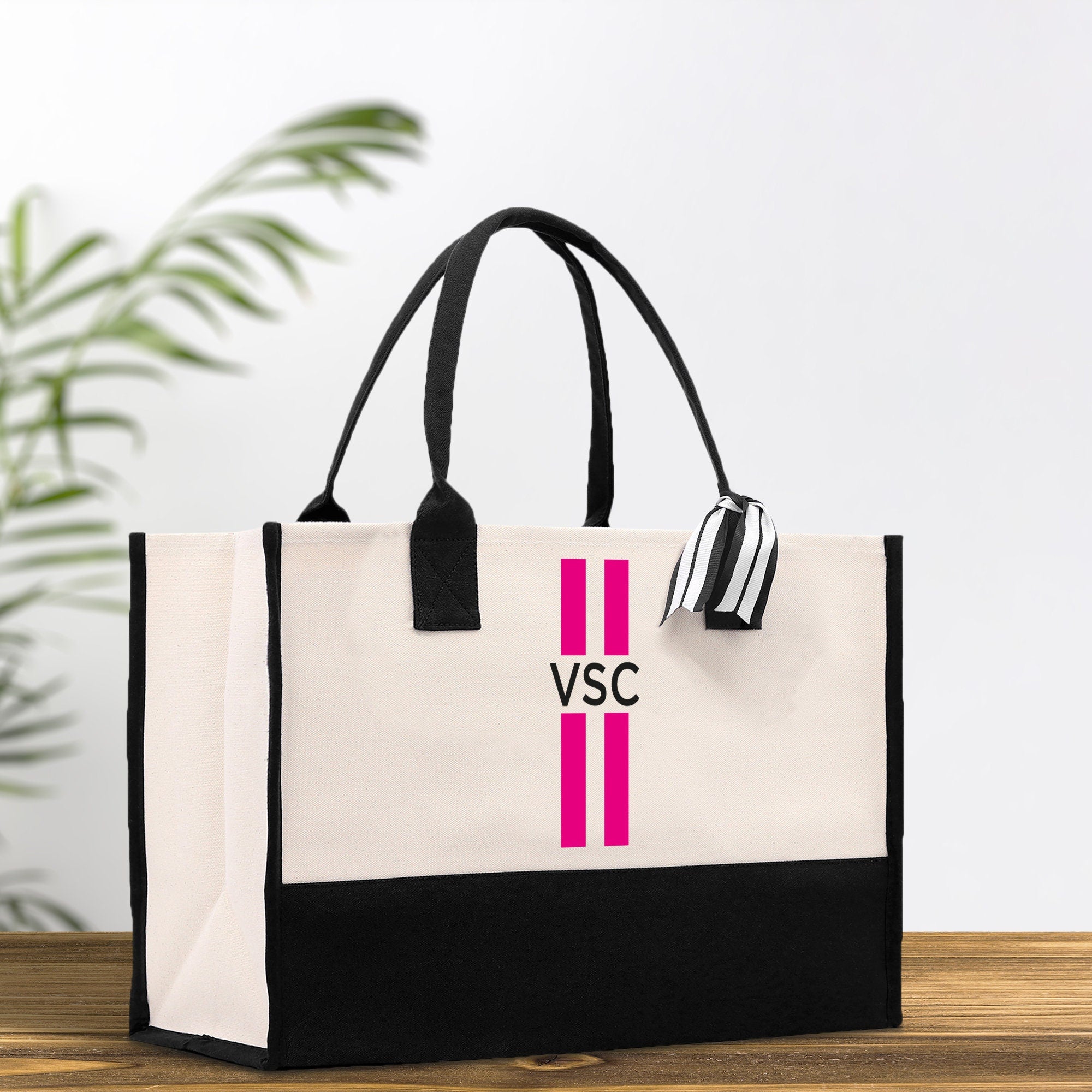 a black and white bag with a pink cross on it
